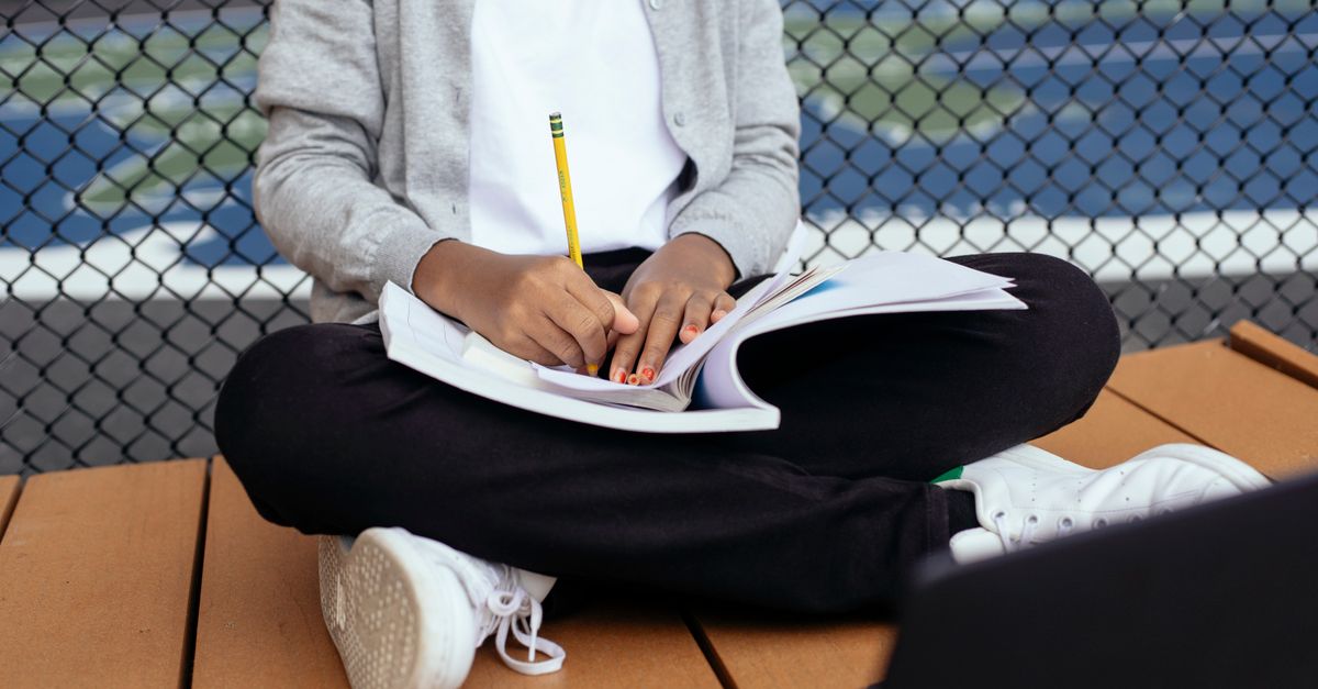 child writing in notebook