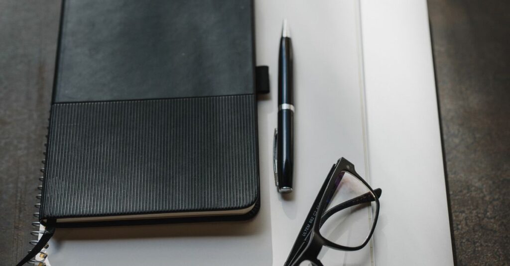 stack of notebooks with pen
